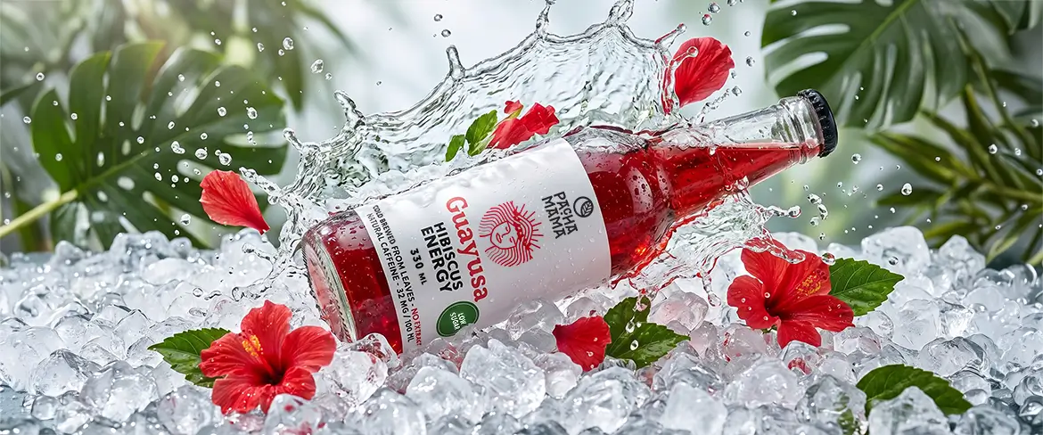 Bouteille de Guayusa Pachamama Cold Brew sur de la glace pilée, agrémentée de fleurs d'hibiscus.